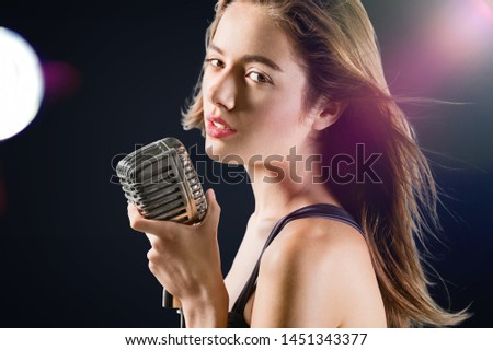 Beautiful singing girl curly afro hair. Beauty woman singer sing with microphone karaoke song on stage. Dark background, smoke, spotlights
    
    - Image
