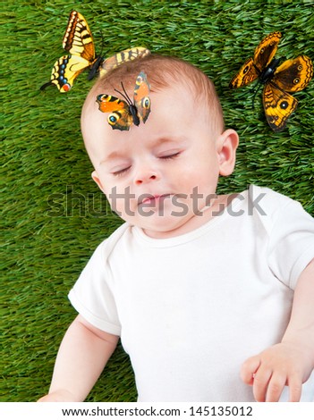 Artificial butterfly sits on the face of a cute little child