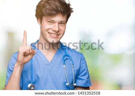 Young doctor wearing medical uniform over isolated background showing and pointing up with finger number one while smiling confident and happy.