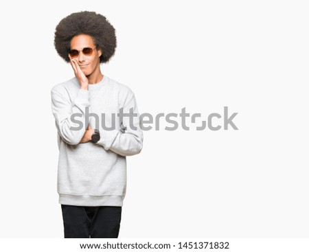 Young african american man with afro hair wearing sunglasses thinking looking tired and bored with depression problems with crossed arms.