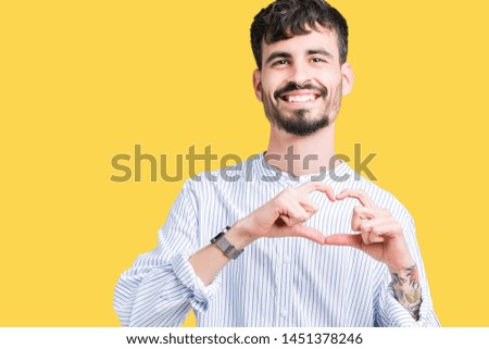 Young handsome business man over isolated background smiling in love showing heart symbol and shape with hands. Romantic concept.