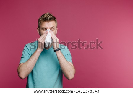 studio picture from a young man with handkerchief. Sick guy isolated has runny nose. man makes a cure for the common cold
