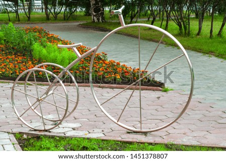 A Parking place for bicycles, metal Bicycle sign on the background of flower beds, cityscape