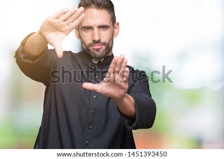 Young Christian priest over isolated background Smiling doing frame using hands palms and fingers, camera perspective