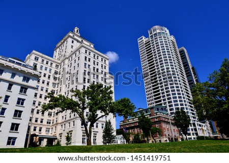Beautiful large white buildings in downtown Milwaukee contrasting against a blue sky as seen from Juneau Park 