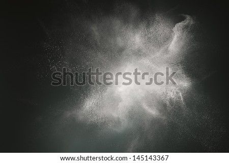 Abstract design of white powder cloud against dark background Royalty-Free Stock Photo #145143367