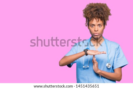 Young african american doctor woman over isolated background Doing time out gesture with hands, frustrated and serious face