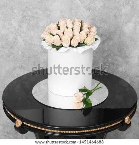 Bouquet of flowers in a round hat box on a black table