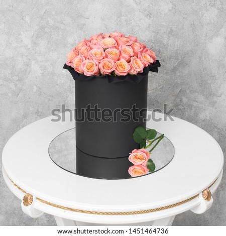 Bouquet of flowers in a round hat box on a white table