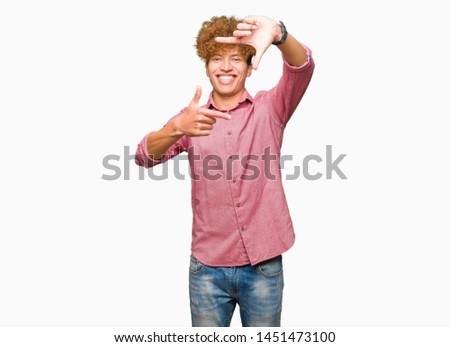 Young handsome business man with afro hair smiling making frame with hands and fingers with happy face. Creativity and photography concept.