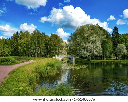 Beautiful summer landscape with an old park and a bridge on the lake. Gatchina.