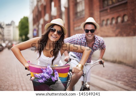 Happy couple cycling in the city Royalty-Free Stock Photo #145149241
