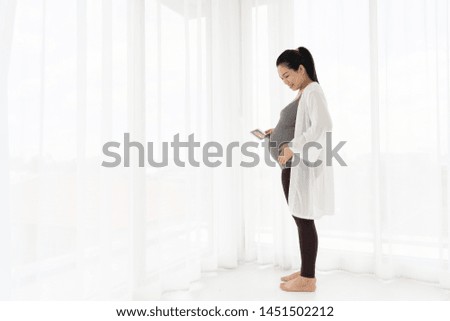 Happy Pregnant woman holding ultrasound image. Concept of pregnancy