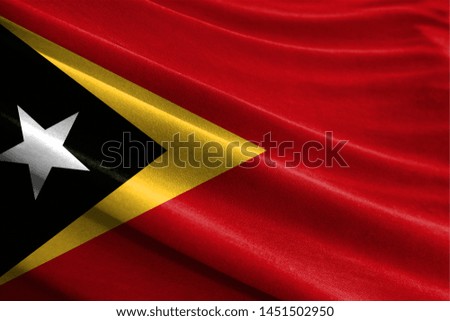Realistic flag of East Timor on the wavy surface of fabric