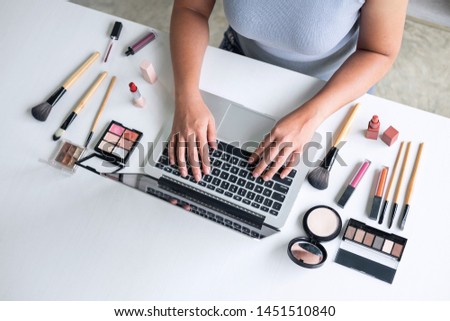 Business online on social media, Beautiful woman is watching online blogger tutorial on laptop, showing present tutorial beauty cosmetic using product makeup.