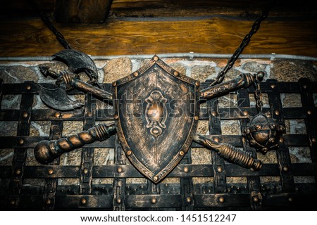Shield axe and sword hanging on the wall.