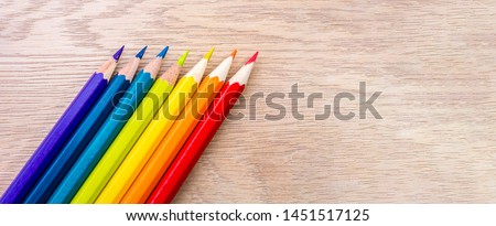 Different colored pencils photo with space for text. Seven pencils of rainbow colors lie on the table. Copyspace. Back to school. Wooden background. Royalty-Free Stock Photo #1451517125