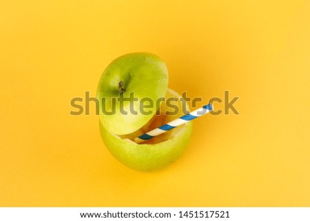 Healthy Green Cut Apple recyclable paper straw juice drink idea concept on yellow background 