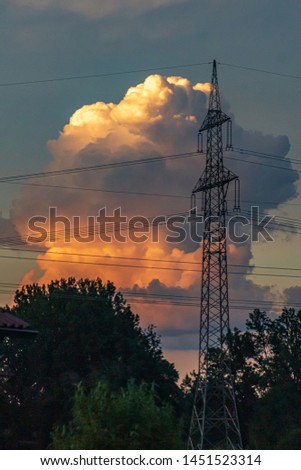 Beautiful stormcloud at sunset with powerline silhouette at Aholming, Bavaria, Germany