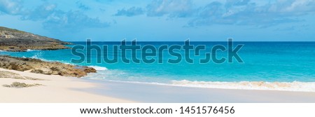 Waves crashing along a beach in the Caribbean. Perfect blue water, ominous clouds, and clear skies. Water is powerful! 