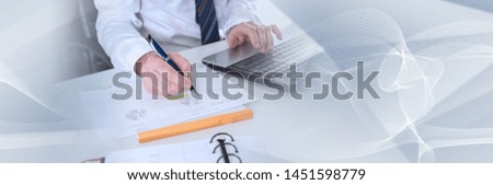Businessman working with documents and laptop; panoramic banner