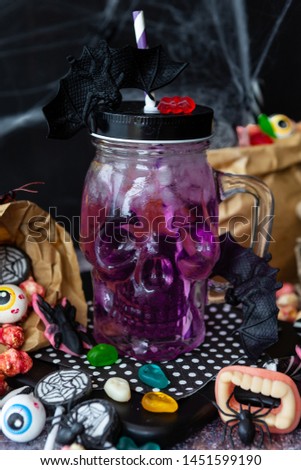 Ice cold cocktail and colorful sweets for Happy Halloween