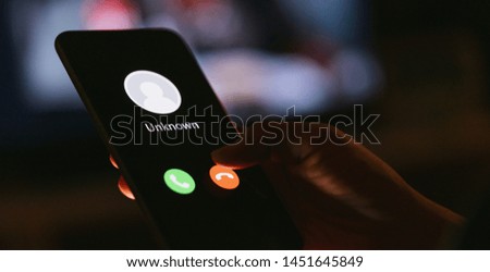 Unknown number calling in the middle of the night. Phone call from stranger. Person holding mobile and smartphone in livingroom late. Unexpected call disturbs at night. Royalty-Free Stock Photo #1451645849