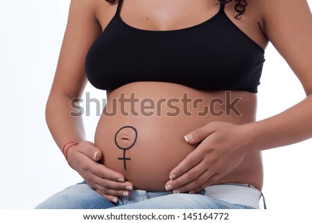 The tummy of a woman far gone with child, having the Venus sign playfully drown around the navel, hand on her abdomen. 