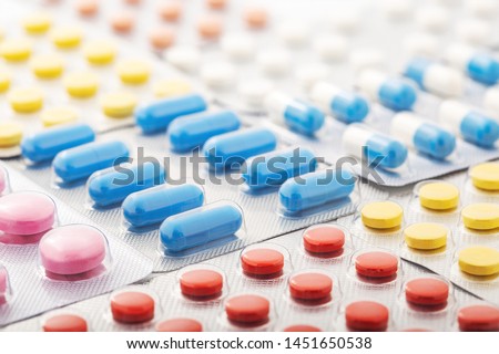 Heap of medical pills in white, blue and other colors. Pills in plastic package. Concept of healthcare and medicine. Royalty-Free Stock Photo #1451650538