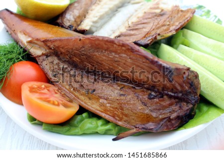 Smoked mackerel on a plate. mackerel with lemon and vegetables