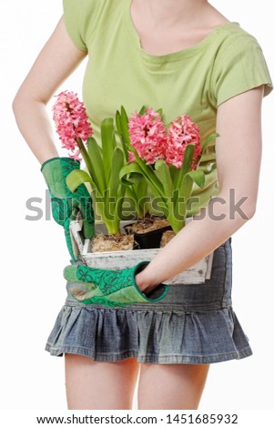 Woman holds a wooden box with pink hyacinth flowers.