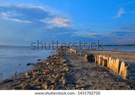The photo was taken in Ukraine in the vicinity of Odessa. The picture shows the remains of a long wooden pier, shot at the end of the day on the estuary called Kuyalnitsky.