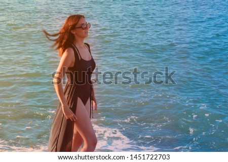 beautiful teen girl bathing in the sea at sunset