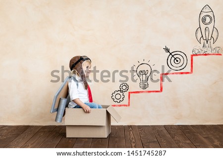 Funny kid with toy jet pack. Happy child playing at home. Success, imagination and innovation technology concept Royalty-Free Stock Photo #1451745287
