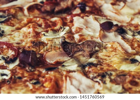 Close-up of Delicious Fresh Pizza with mushrooms, Bavarian sausages, ham