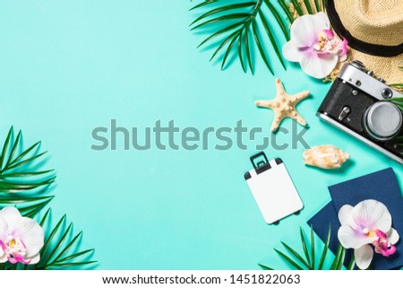 Summer holiday flat lay background. Old film camera, hat, shell and palm leaves on blue background. Top view. Flat lay.