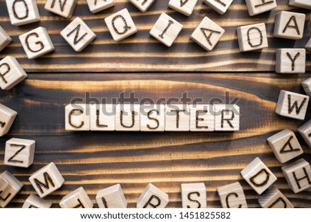 cluster composed of wooden cubes with letters, a group of businesses or loosely coupled computers that work together concept, scattered around the cubes random letters, top view on wooden 