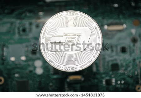 silver cryptocurrency coin - dash, on background of computer motherboard. 