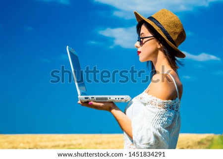 photo of the beautiful young woman with laptop in the field