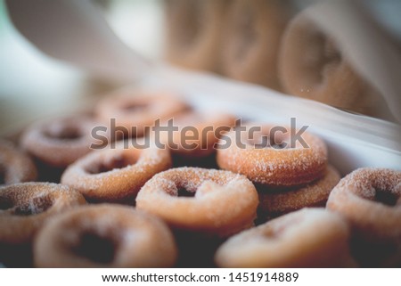 A box of freshly baked doughnuts dusted in sugar.