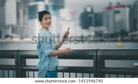 Asia woman using smartphone selfie on Hong Kong Central waterfront