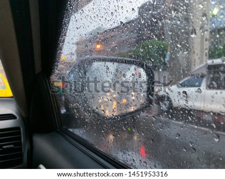 View looking out of a car window with rain drops, traffic jam during rush hour