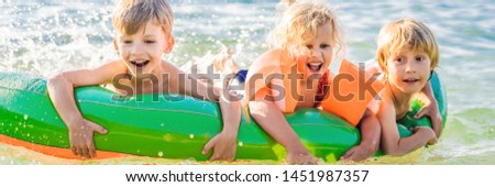 Children swim in the sea on an inflatable mattress and have fun BANNER, LONG FORMAT