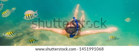 Happy young woman swimming underwater in the tropical ocean BANNER, LONG FORMAT