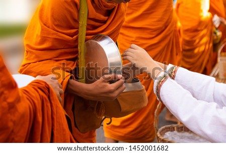 Thai people are offering food to the monks in the bowl. On Buddhist important days Royalty-Free Stock Photo #1452001682