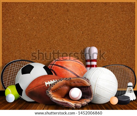 Sports equipment, rackets and balls on table with background corkboard and copy space.