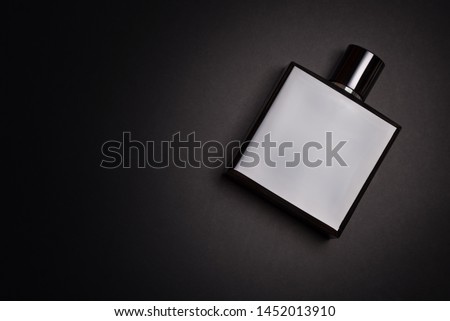 Mockup of black fragrance perfume bottle mock up on dark or black empty background. Top view. Horizontal photo with copy space