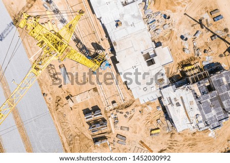 top view of high yellow tower crane standing at construction site. drone image