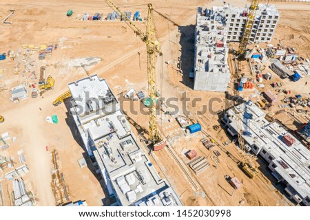 aerial image of city construction site with yellow tower cranes. drone photography