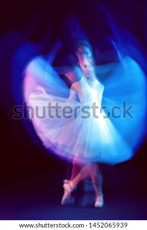 A full length portrait of a refined female ballet dancer posing in the studio over the black background. Talent, fashion for ballet dancers. 